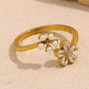 Macro detail of 18K gold flower ring with white pearls and clear crystals