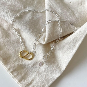 Detailed close-up of S925 sterling silver stamp and interlocking gold-tone CD pendant