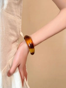Detail of a thick irregular acrylic resin cuff with tortoise shell amber pattern textures