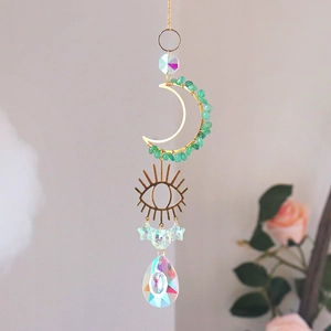 Macro detail of golden moon and eye pendant with colorful teardrop crystal prism
