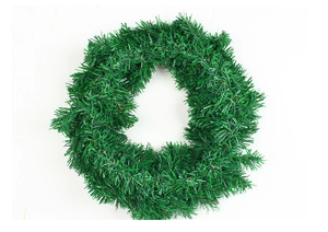 Detailed top view of green artificial pine needle Christmas wreath on white background