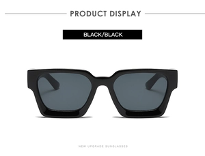 Detalle de gafas de sol rectangulares en negro brillante con lentes oscuras y marco