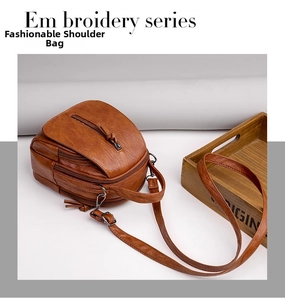 Close-up of vintage brown PU leather crossbody bag with multiple zipper compartments