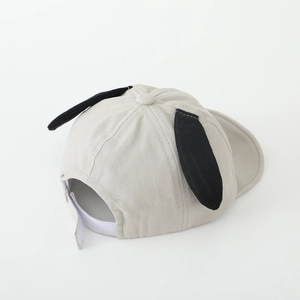 Detail view of cotton baby cap showing long dog ears and adjustable velcro strap back