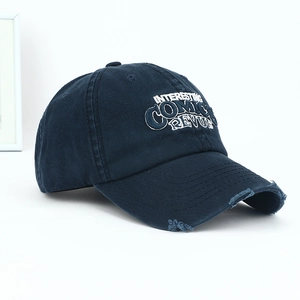 Vintage washed navy blue baseball cap with distressed brim and comic embroidery detail