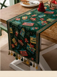 Close-up of green Christmas table runner with tassels, gift patterns and festive weaving