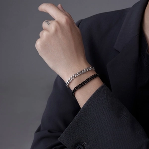 Sleek stainless steel Cuban link bracelets in silver and black shown on a wrist
