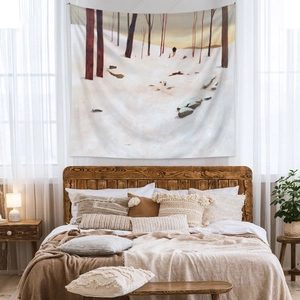 Detail view of Bohemian winter forest landscape tapestry hanging over a bed in bedroom