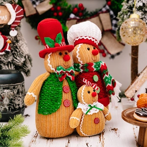 Three Christmas gingerbread man knit dolls in red, green and yellow festive holiday scene