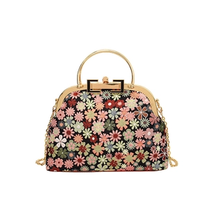 Retro black floral shell bag with gold handle and chain strap on white background