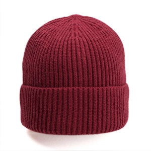 Detailed view of dark red ribbed knit texture and wide folded cuff on warm winter beanie