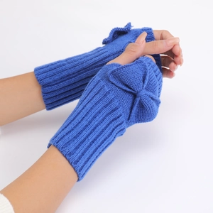 Detail of blue knit fingerless gloves showing bow decoration and soft textured wool yarn