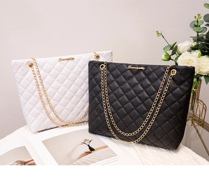 Détail du matelassage et de la chaîne dorée sur les sacs cabas noir et blanc