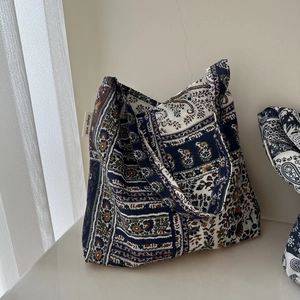 Close-up of Bohemian linen shoulder bag with intricate paisley print and brand label