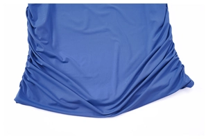 Close-up of the royal blue ruched fabric texture on a high-waisted bodycon mini skirt