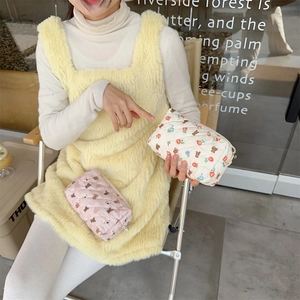 Detailed shot of floral and bear quilted makeup pouches with soft texture and metal zippers