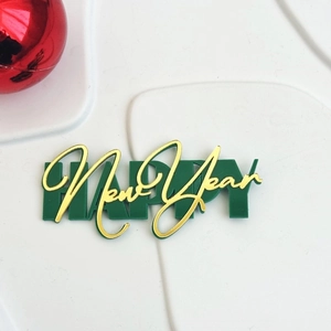 Detail of green and gold acrylic Happy New Year cake topper for festive party decor