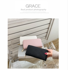 Detailed view of quilted long wallets with vertical stitching and gold zippers in three colors
