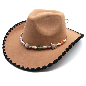 Detail of western brown felt hat with woven brim edge and beaded star decorative band