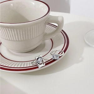 Detailed view of S925 sterling silver rings with rectangular zircon stones on ceramic