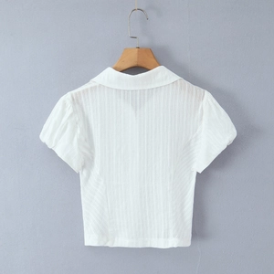Detailed view of the white polo shirt with textured vertical stripes and puffed short sleeves