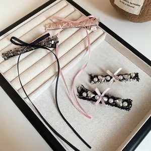Elegant 4-piece hair clip set with lace bows, pearls, and crystals in a display tray