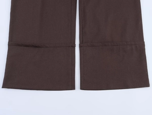 Close-up of the hem stitching and woven texture on dark brown linen wide-leg pants