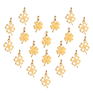 Golden clover stainless steel necklace pendants arranged in heart shape on white background