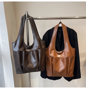 Detail of vintage tote bags in dark brown and caramel showing multi-pocket PU leather design