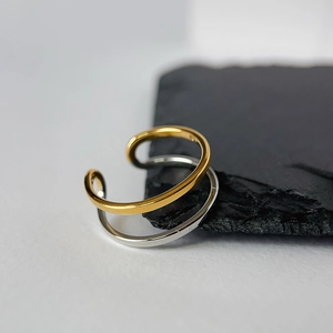 Minimalist gold and silver two-tone double layer ear cuff set on stone background