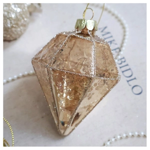 Detail of champagne gold diamond-shaped glass ornament with vintage texture and glitter