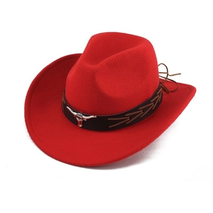 Detail of red cowboy hat featuring brown decorative band and silver bull head emblem