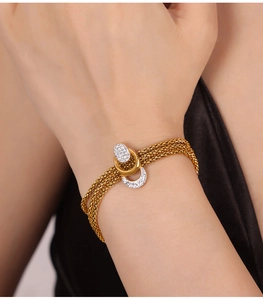 Close-up of gold-plated multi-strand bracelet with crystal-studded decorative clasp
