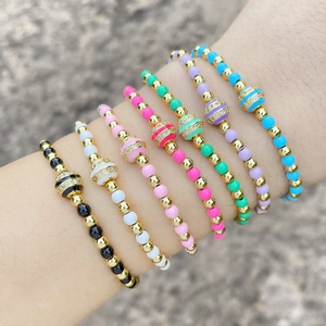 Set of 7 colorful beaded bracelets with gold metal accents and rhinestone sphere charm