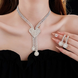 Close-up of sparkling rhinestone heart necklace and earrings set on a model wearing black