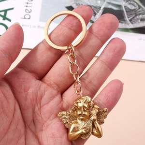 Detailed close-up of a golden cupid angel keychain playing harp with a vintage finish