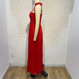 Detail of red tiered maxi dress with ruched elastic bodice and thin straps
