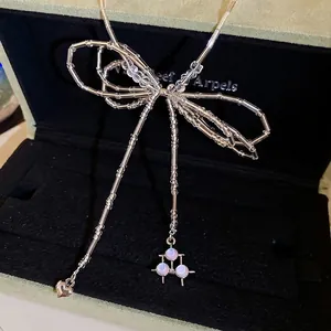 Elegant crystal beaded bow necklace with heart pendant on a velvet jewelry display