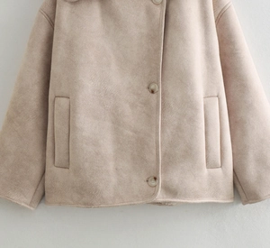 Detailed view of light beige faux suede jacket with textured buttons and side pockets