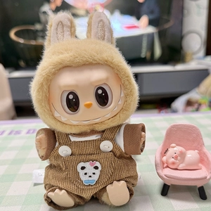 Detail showing plush doll wearing brown corduroy overalls with white bear embroidery