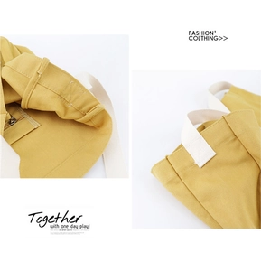 Detail of a ginger yellow canvas tote bag showing stitching and internal zipper pocket