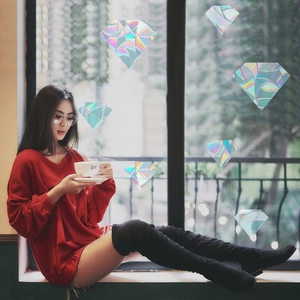 Rainbow prism diamond window decals casting colorful light shadows on an indoor scene