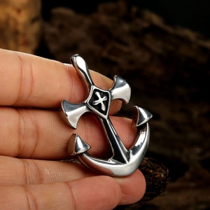 Detailed close-up of a polished stainless steel anchor pendant with black cross inlay