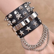 Detail of punk multi-layer black leather bracelet with silver skull and metal studs