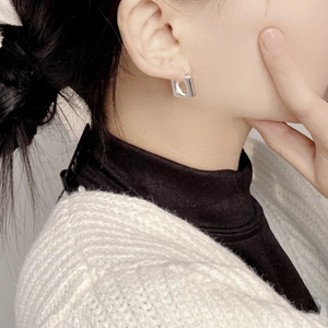 Close-up of minimalist square silver hoop earrings worn on a model with elegant detail