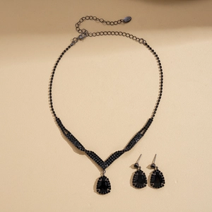 Flat lay of vintage style black crystal teardrop necklace and matching earrings set