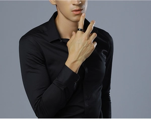 Close-up of minimalist black tungsten ring worn by male model for a business look