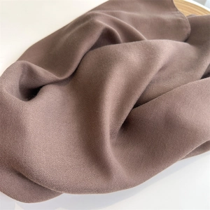 Detailed close-up showing texture and soft drape of the brown cotton linen scarf