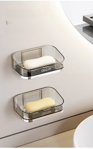 Detail of wall-mounted transparent soap holders in amber gold and silver finish options