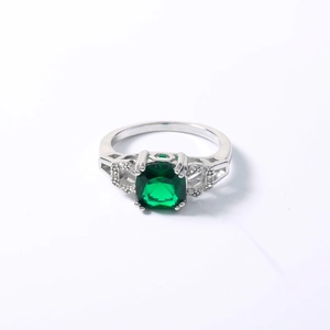 Close-up of emerald green square gemstone ring with hollow band and silver setting